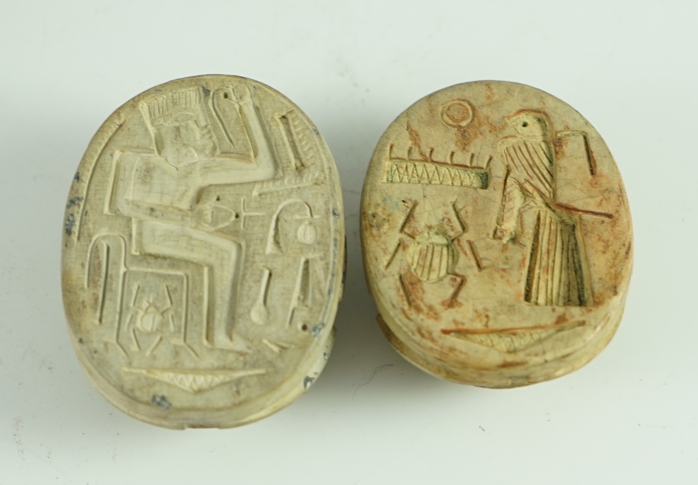 A group of antiquities comprising two commemorative scarabs, an Egyptian style gypsum head, and two antique terracotta heads